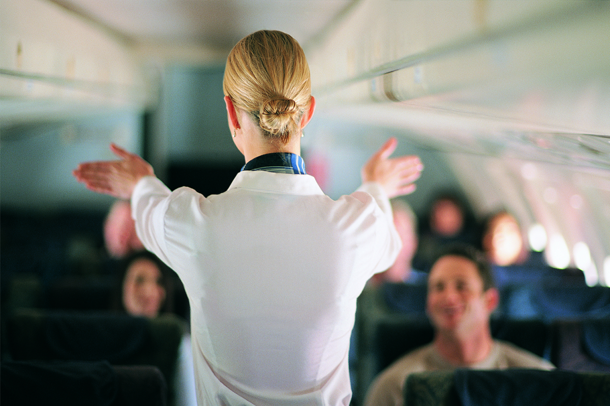 Hvorfor står stewardesser med hænderne bag på ryggen, når du træder ind på flyet? – Det er ikke bare høflighed!